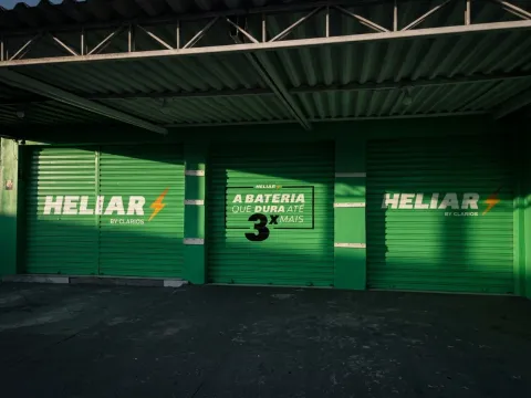 Vista de fileira de portas comerciais pintadas em verde sob toldo metálico — acabamento uniforme