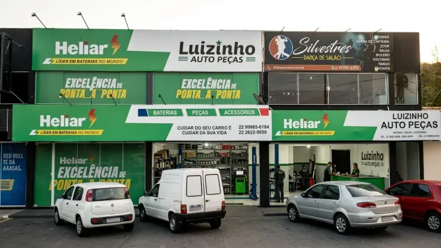 Fachada comercial com pintura externa concluída em verde e branco — escala urbana