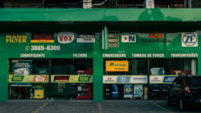 Fachada em ACM vista de frente na rua — perspectiva ampla da loja